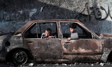 Children sit inside a destroyed car in Rafah.