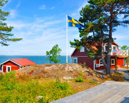 View of two houses and the sea from the island of Aspöja on Sweden’s Östergötland archipelago, on a blue-sky day.