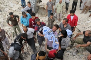 Syrians pass the body of child after digging it out from under the rubble of a building