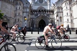 Participants cycle past The Royal Courts of Justice