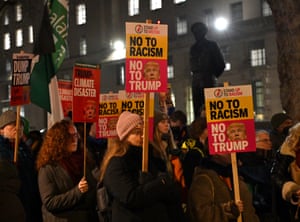 people hold signs that say 'No to racism, no to Trump' and 'Trump: climate disaster'