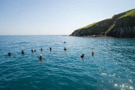 About 10 young carers snorkelling in the sea off Lundy, Devon.
