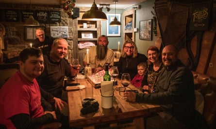 A smiling group of people sitting around a table in the pub