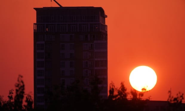 The sun rises from behind an apartment block in east London