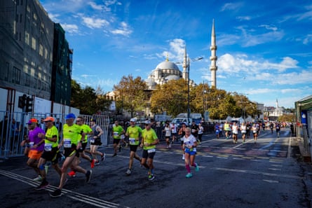Athletes in the Istanbul Marathon running past large Turkish mosque