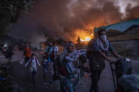 Refugees and migrants flee fire at the Moria camp on Lesbos in September. Successive fires made 12,000 inhabitants homeless (AP Photo/Petros Giannakouris)