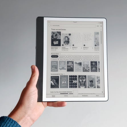 A hand holds up a tablet showing an e-reader app with a bookstore homepage displayed