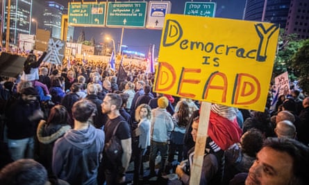 A protester holds a sign at a demonstration in Tel Aviv on Saturday night
