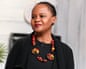 Author Edwidge Danticat speaks, wearing a black outfit and colorful beaded necklace