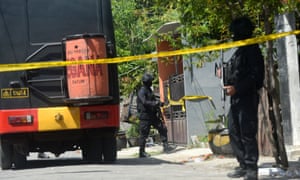 Officer outside the house of family who carried Mondayâs bombing of Surabayaâs police headquarters.