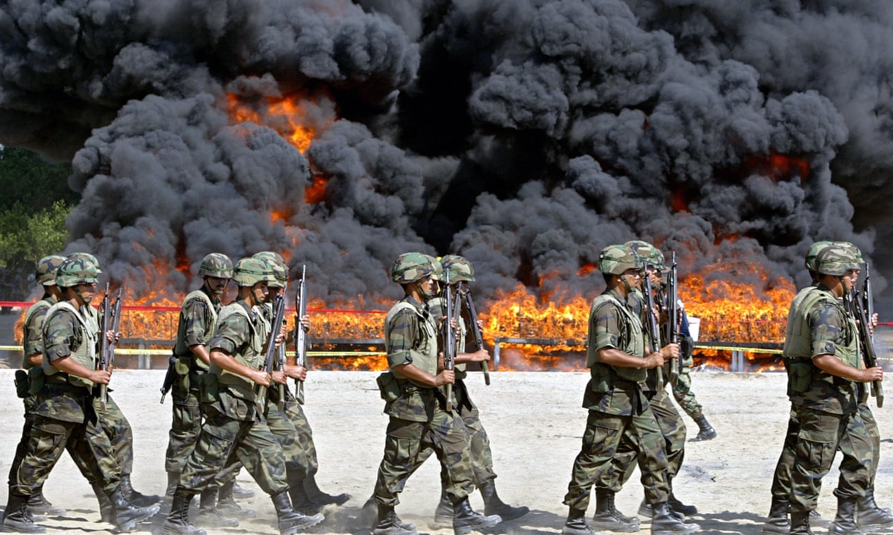 Mexican soldiers walk next to the site of the incineration of more than 20 tons of cocaine in Manzanillo.