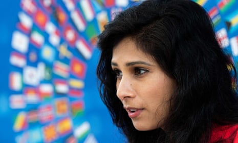 Gita Gopinath in close-up as she stands in front of an image of national flags, giving the impression they are radiating in a circle around her head