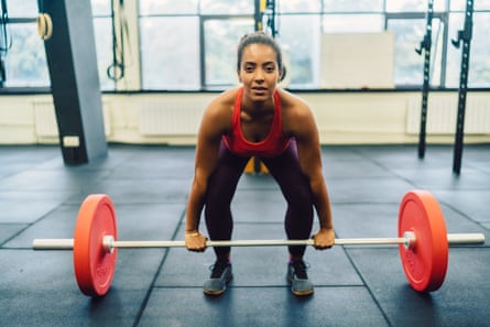 Woman in gym deadlifting.