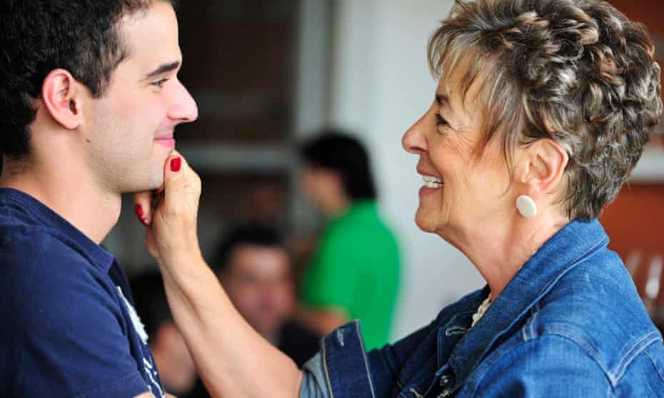 Hispanic grandmother pinching grandsons face