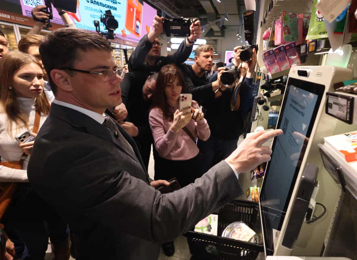 Boyarsky tapping a screen as people take photos of him