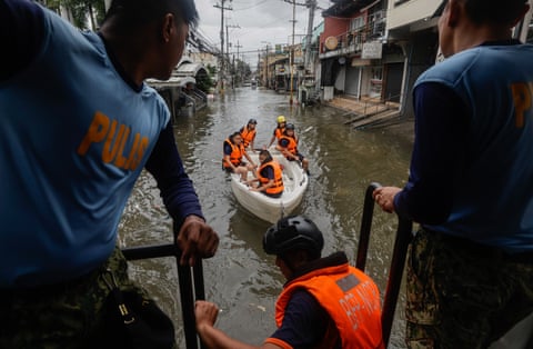 Fire personnel on a raft and police in a flood street
