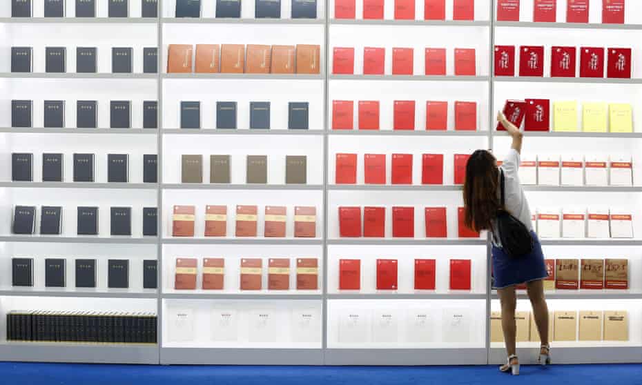 Time to reach higher? … a woman takes a book from a shelf at the 2017 international book fair in Beijing.