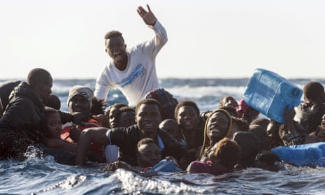 Migrants on a partially submerged dinghy in the Mediterranean Sea on 27 January 2018.
