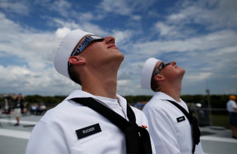 U.S. Navy sailors Soloman Rucker (Front) and Peyton Warner check the position of the sun on the flight deck of the Naval museum ship U.S.S. Yorktown during the Great American Eclipse in Mount Pleasant, South Carolina.