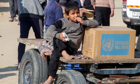 A Palestinian boy sits beside an aid box provided by Unrwa outside a distribution point in Khan Younis in the southern Gaza Strip.