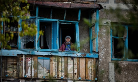 An elderly woman stands on the balcony of her damaged home following a shelling on the town of Bakhmut in Donetsk region, on 25 October.