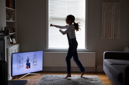 A 12-year-old girl does a Joe Wicks YouTube morning workout session.