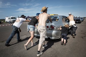 All hands on deck to manoeuvre a car down the queue of entrants.
