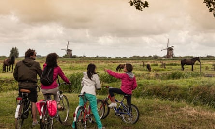 A family on bikes takes in the sights of Kinderdijk.