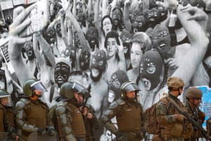 Military stand in front of a mural in Santiago