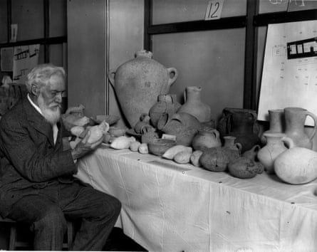 Egyptologist Sir Flinders Petrie examining pottery lined up on a table