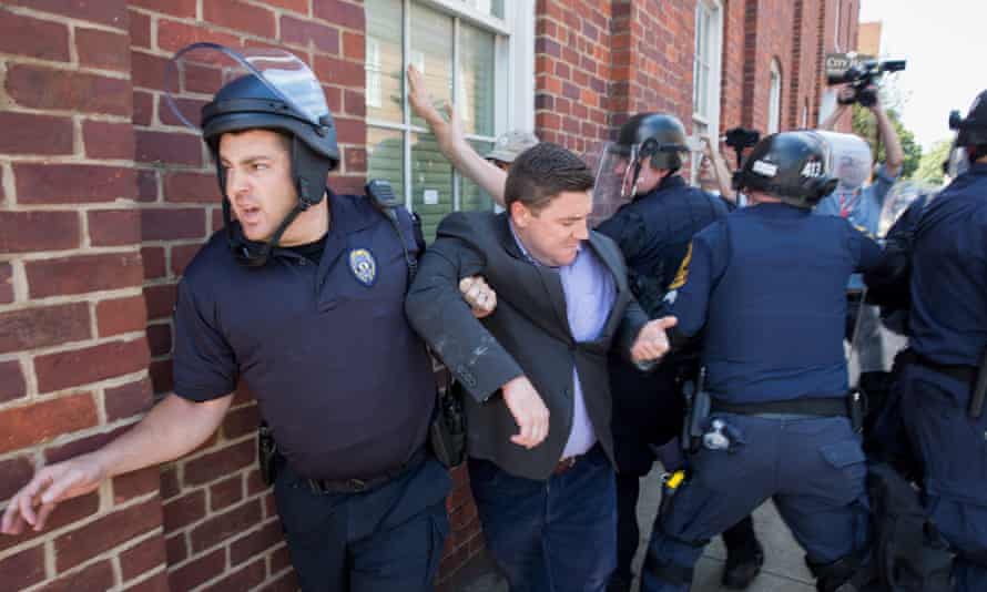 Police escort Jason Kessler away from his press conference in Charlottesville.