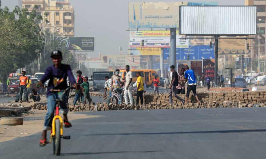 Protesters build a brick barrier blocking on a main road in the capital Khartoum, during a demonstration against rising prices on 24 January.