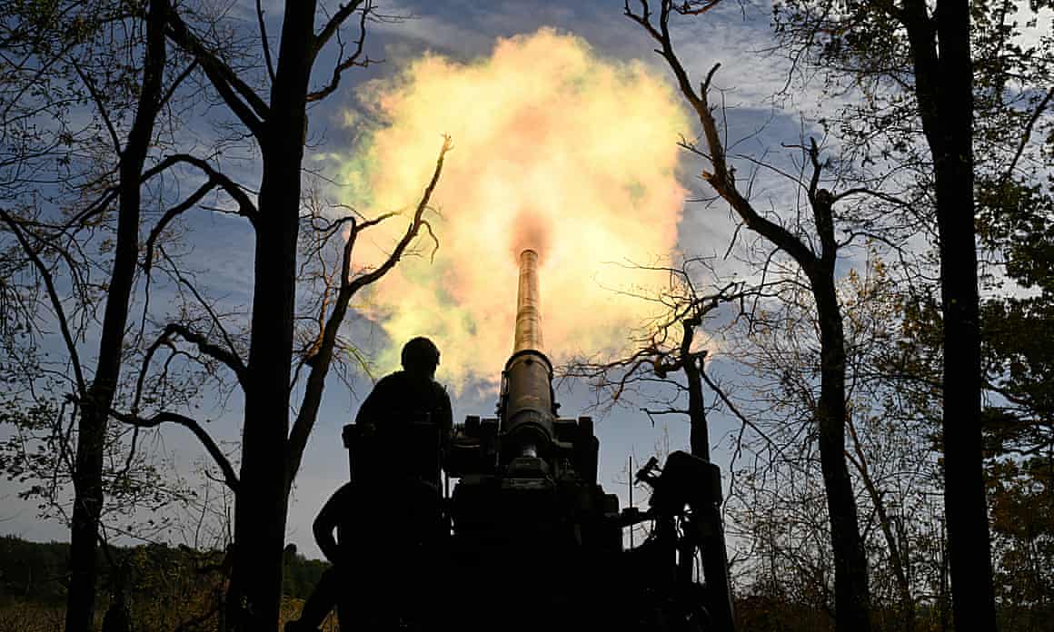 An explosion of flames can be seen erupting from the barrel of artillery amid mainly leafless trees and darkened skies