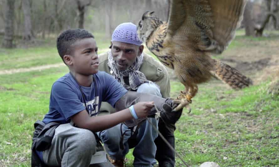 Rodney Stotts teaches student Javiare Harris to pick up his Eurasian eagle-owl, Mr Hoots.