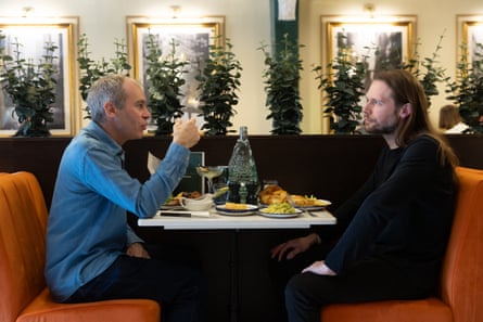 Philip and Carl chatting and eating at a restaurant table