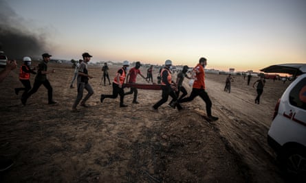 A Palestinian injured in a demonstration is carried on a stretcher by medical rescue personnel, Gaza Strip