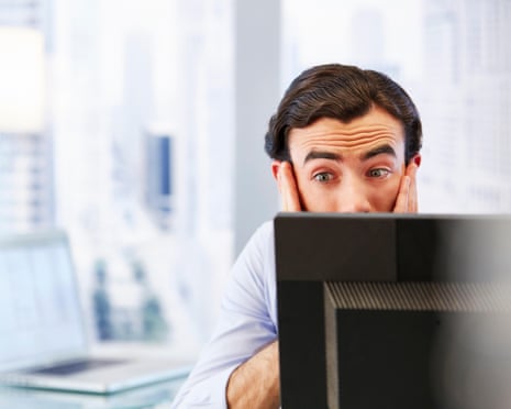 Man using computer in office, stressed and worried.