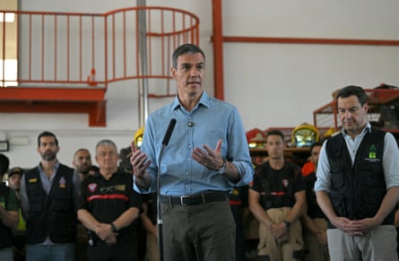 Pedro Sánchez holding a press conference, with firefighters in the background