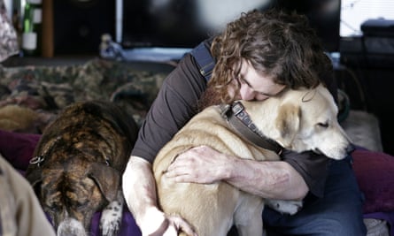 A man hugs his dog in a temporary city-approved area for people living in their vehicles in Seattle. The number of homeless people in the county that includes the city rose by 1,000 between 2016 and 2017.