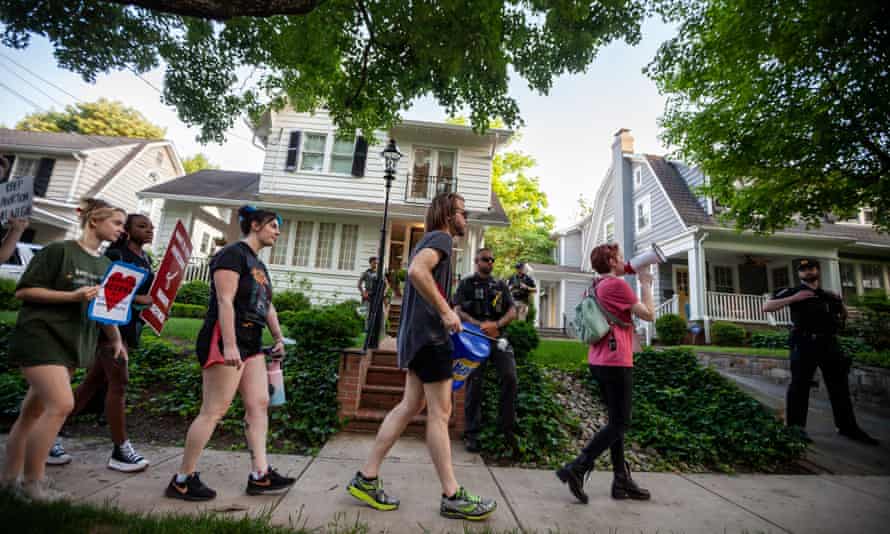 Pro-choice protesters pass in front of Supreme Court Justice Brett Kavanaugh’s house in Chevy Chase, MD, as Montgomery County Police and federal marshals stand guard.
