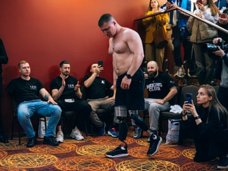 Drobotenko walking across a room as people photograph him