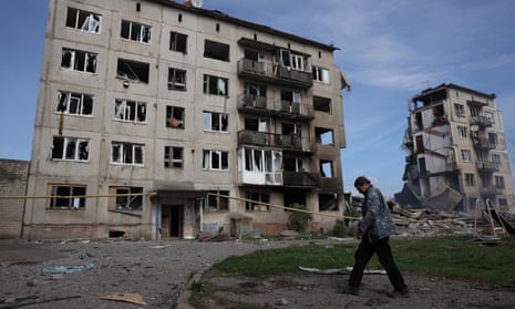 A local resident walks past apartment buildings destroyed by air bomb in the village of Ocheretyne, not far from Avdiivka town in the Donetsk region, on 15 April 2024.