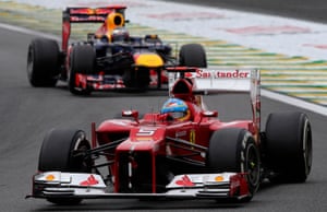 Ferrari's Fernando Alonso steers his car in front of Red Bull's Sebastian Vettel.