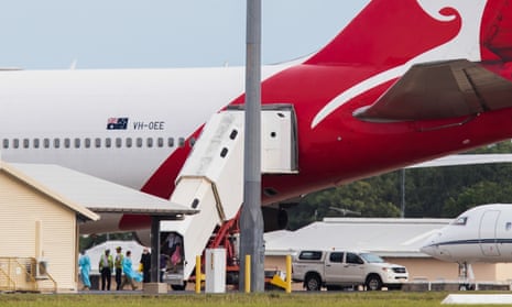 Australian evacuees from the coronavirus-struck cruise ship Diamond Princess leave a Qantas flight from Japan at Darwin airport to go into quarantine. 