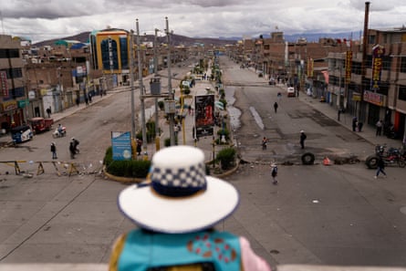 A woman looks out from an overpass at a road closed by anti-government protesters in Juliaca.