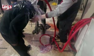 An image from a video released by the Douma City Coordination Committee shows volunteers spraying a man with water at a makeshift hospital after an alleged chemical attack.