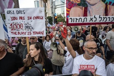 People hold up signs and shout through megaphones