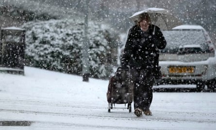 Une femme traverse une tempête de neige dans le Cheshire.
