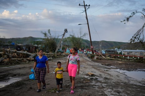 Residents walk in the aftermath of Hurricane Melissa in El Cobre, Cuba, Wednesday, Oct. 29, 2025.