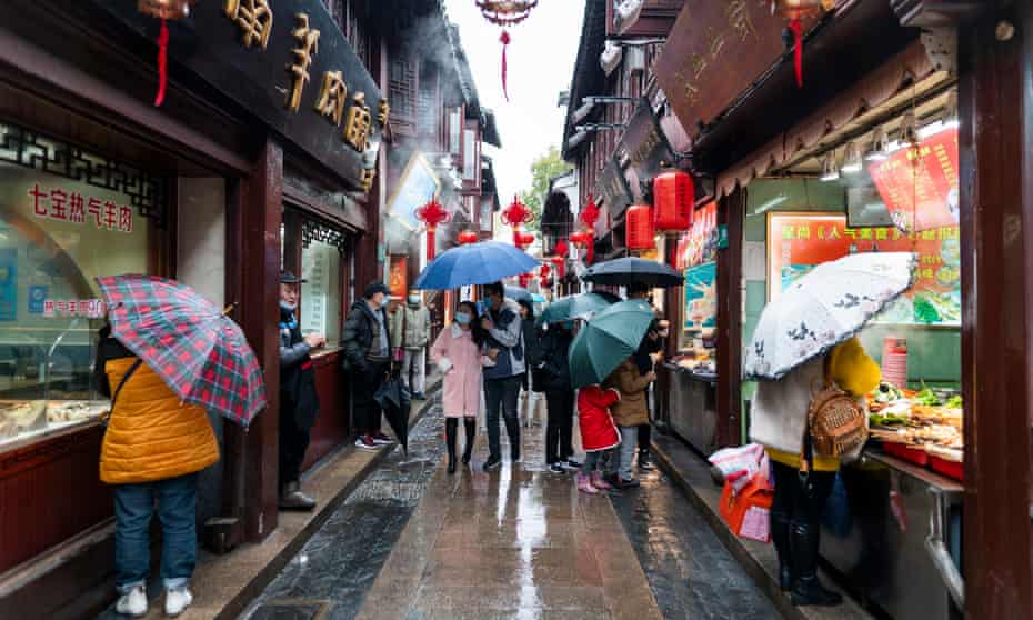 People walk through a street in Shanghai